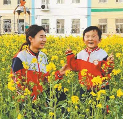 黄金堤乡金乡水岸幼儿园老师给孩子讲解油菜花.jpg